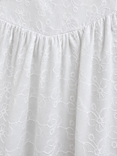 Load image into Gallery viewer, Close-up of a white embroidered cotton fabric nightgown with a gathered neckline and floral embroidery pattern.